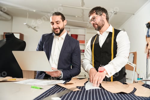 Preview: Tailors Discussing Bespoke Suit Design in Workshop