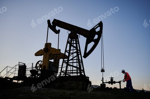Preview: Operator working with wrench on pipeline near the oil well.