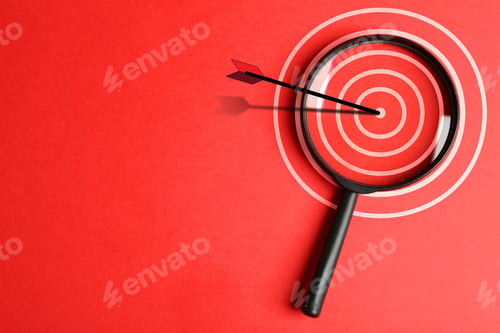 Preview: Magnifying glass with illustration of target and arrow on red background, top view. Space for text