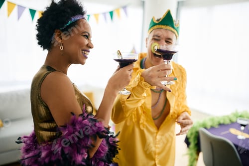 Preview: Carefree multiracial friend toasting on Mardi Gras celebration party.