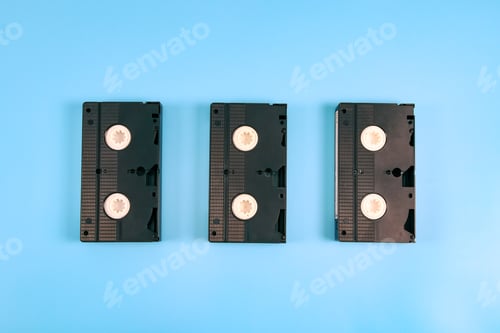 Preview: Three retro videotapes lie in the middle on a blue.