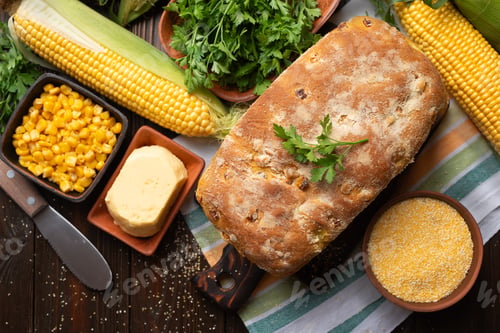 Preview: Cut board with fresh cornbread on wooden kitchen table flat lay view