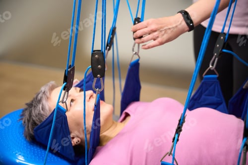 Preview: Trainer preparing suspension medical ropes for hanging of woman after injury