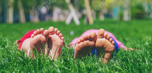 Preview: Children's feet on the grass. Selective focus.