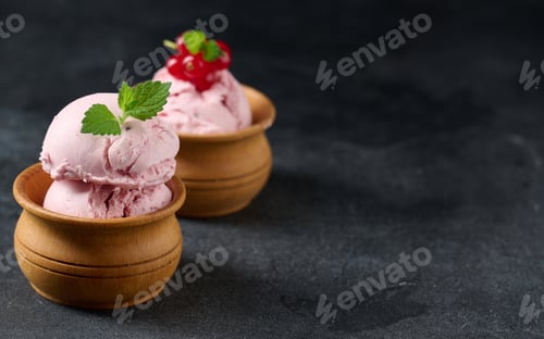 Preview: Pink scoops of popsicles with red currants on a black table. Ice cream