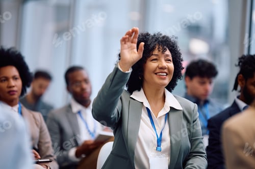 Preview: Happy business seminar attendee asking a question from the audience at conference hall.