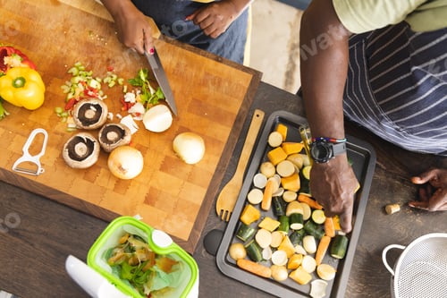 Preview: Senior african american couple wearing aprons and preparing vegetables in kitchen