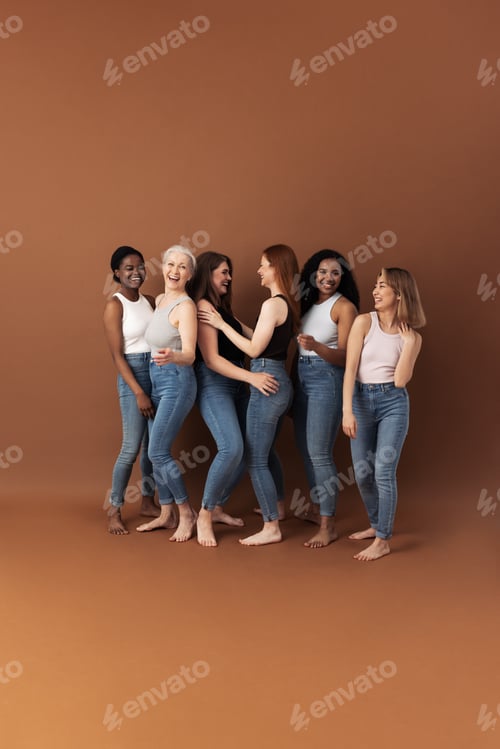 Preview: Six laughing women in casual dancing and having fun against brown background