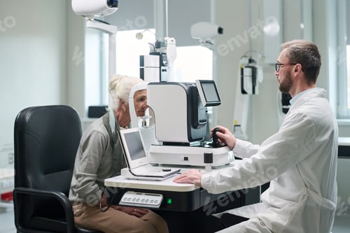 Preview: Senior Woman Undergoing Eye Examination with Male Optometrist