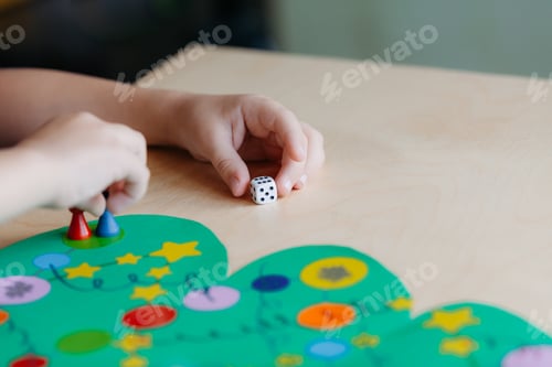 Preview: child hand rolls the dice and moves the chip across the Christmas playing field