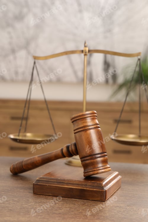 Preview: Wooden gavel, sound block and scales on table indoors