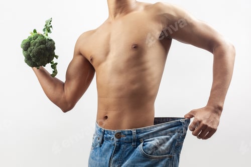 Preview: cropped view man wearing large jeans pant and holding broccoli