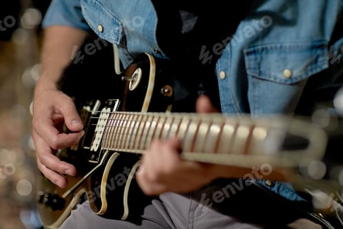 Preview: close up of man playing guitar at studio rehearsal