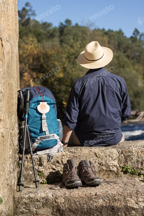 Preview: View from behind of a male pilgrim resting and on his way to Santiago de Compostela