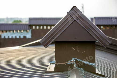 Preview: Close-up detail of new built brick plastered chimneys on house top
