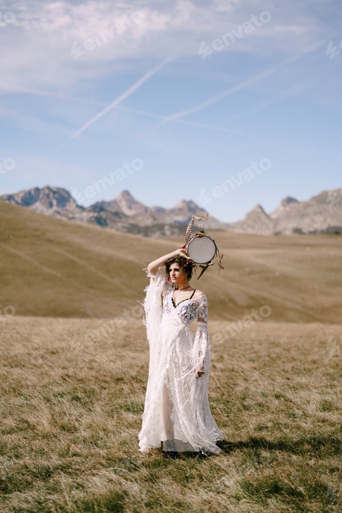 Preview: Girl with a tambourine in her hands stands in a field