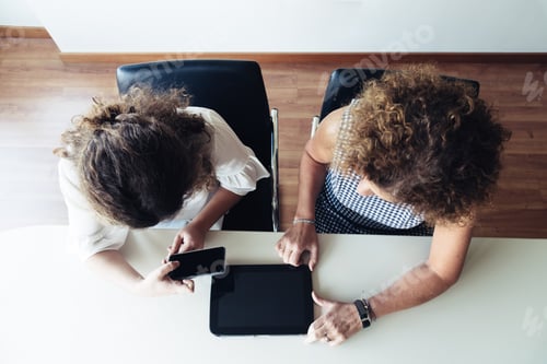 Preview: Two businesswomen working together at office