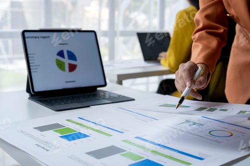 Preview: Businesswoman analyzing financial charts and graphs on desk