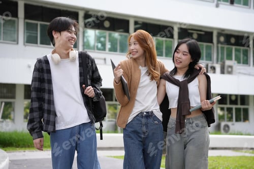Preview: Three asian university students walking together on campus after class, having fun and enjoying
