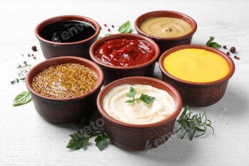 Preview: Many different sauces and herbs on white wooden table