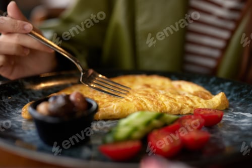 Preview: Woman in cafe eating breakfast omelet with vegetables close-up of fork with food, home-cooked food