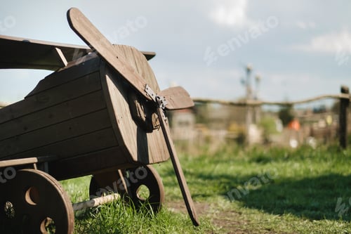 Preview: A wooden model of an airplane standing on the street in summer