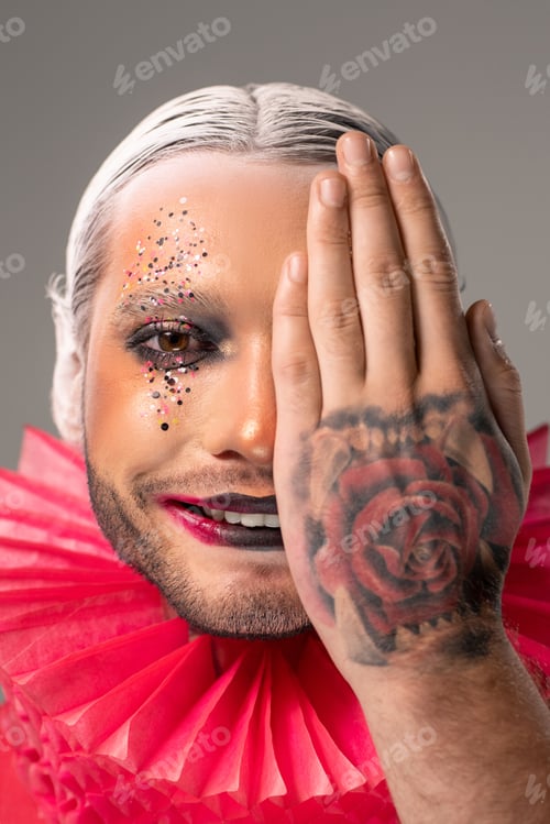 Preview: Portrait of smiling man with makeup covering half part of face