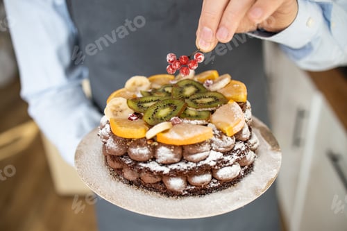 Preview: Close-up Man Chef at Restaurant Kitchen Serves Dish Focused Adding Final Ingredient by Hand. Cooking