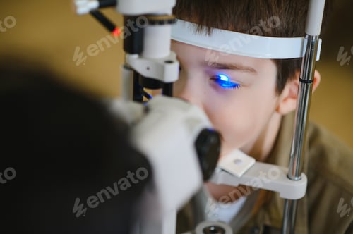 Preview: Ophthalmologist checking child's vision with modern equipment in clinic