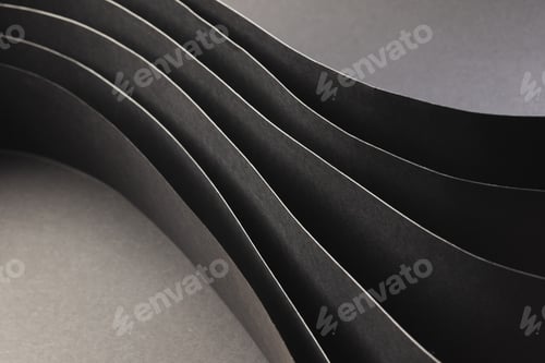 Preview: Close up of rolled up pieces of black paper with copy space on grey background