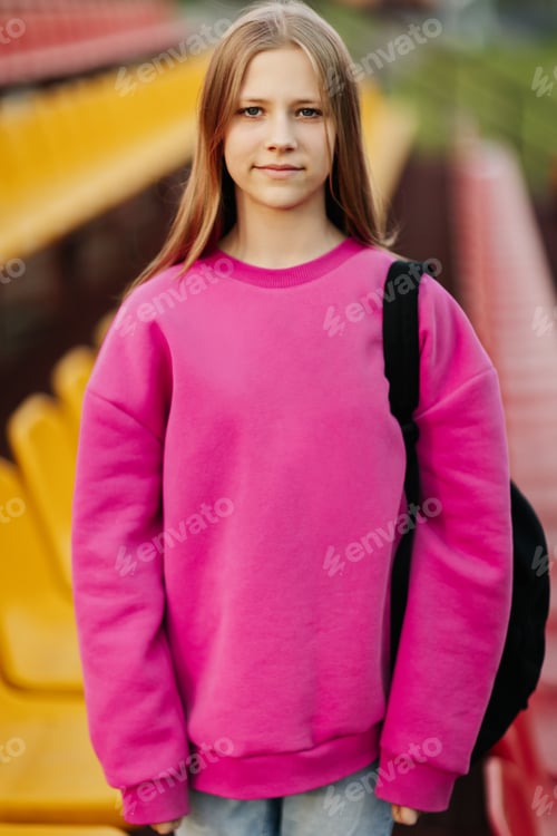 Preview: Portrait of a teenage student looking into the camera, against the background of the school stadium