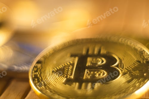 Preview: Closeup shot of gold and silver bitcoins scattered on a surface illuminated with bright light