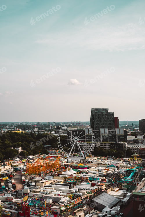 Preview: Aerial view of a vibrant city fairground with Ferris wheel.