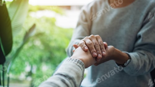 Preview: Women holding each other hands for comfort and sympathy