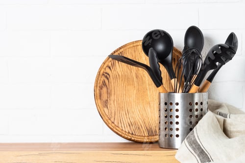 Preview: Cooking tools with wooden cutting boards, oil and shaker at white modern kitchen interior.