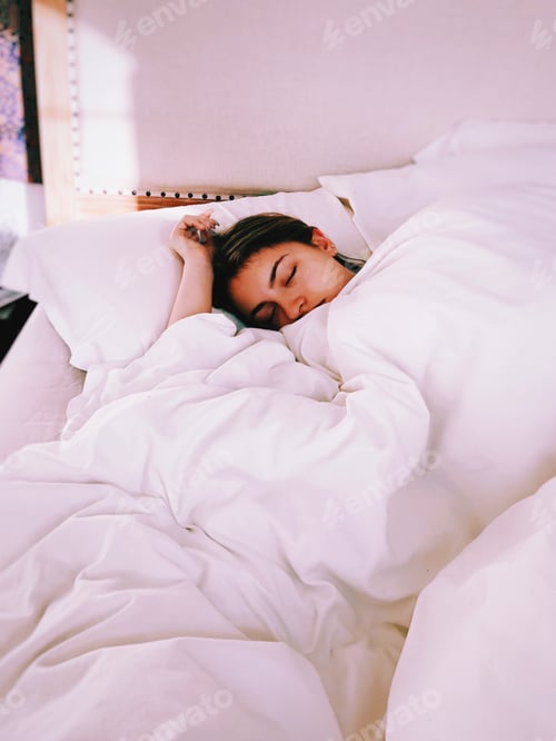 Preview: Young teenage girl sleeping in bed, white bed sheets, morning sunshine