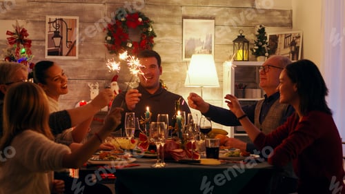 Preview: Cheerful family with different ages holding sparkles