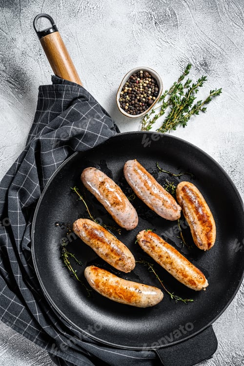 Preview: Grilled assorted pork, beef and chicken sausages with spices in a pan. Gray background. Top view