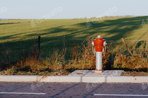 Preview: One above-ground red fire hydrant installed in a rural area.