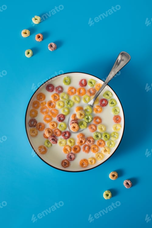 Preview: Colorful breakfast cereal with milk on blue background. Fun snack