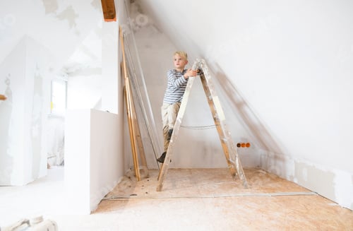 Preview: Boy standing on ladder in attic to be renovated