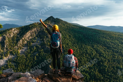 Preview: A traveling couple in hiking gear in the mountains at sunset. Two travelers