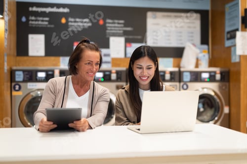 Preview: Two women working on a computer in laundry shop