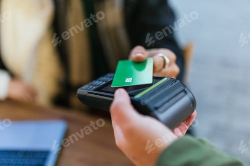 Preview: Close up view of a person making contactless payment with credit card.