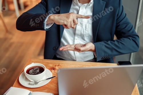 Preview: Businessman have a business meeting via video call and communicates using sign language in cafe