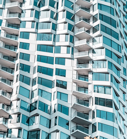 Preview: The image is of a tall building with many windows and balconies