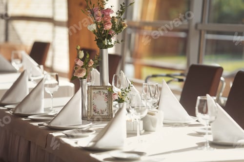 Preview: Table setting with a white tablecloth and natural flowers for the event.