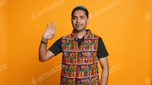 Preview: Person in traditional clothing doing greeting hand gesture, studio background
