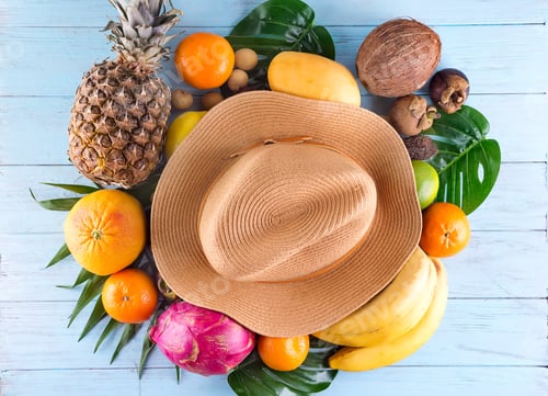 Preview: Summer composition. Tropical palm leaves, hat, many fruits on blue wooden background. Summer concept