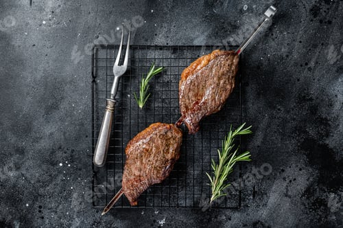 Preview: Picanha, traditional Brazilian barbecue, grilled beef meat steak. Black background. Top view